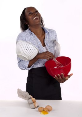 Young woman laughing in kitchen mess clipart