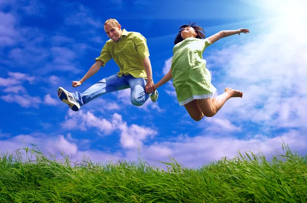 Веселая пара в прыжке на открытом фоне — стоковое фото
