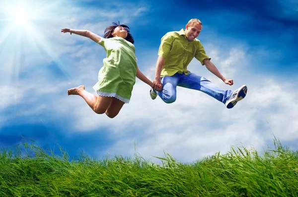 Divertido casal no salto sobre o fundo ao ar livre — Fotografia de Stock