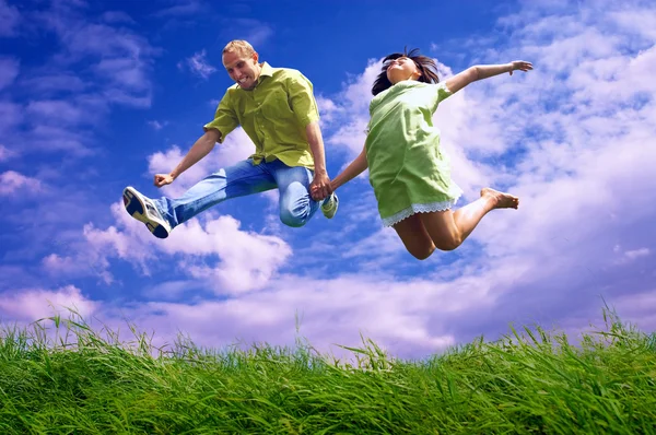 Fun couple in jump on the outdoor background — Stock Photo, Image