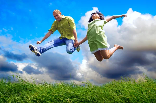 Divertido casal no salto sobre o fundo ao ar livre — Fotografia de Stock