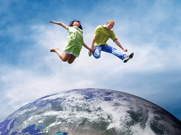 Leuke paar in sprong over de planeet aarde — Stockfoto