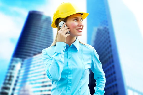 Young architect-woman wearing a protective helmet standing on th — Stock Photo, Image