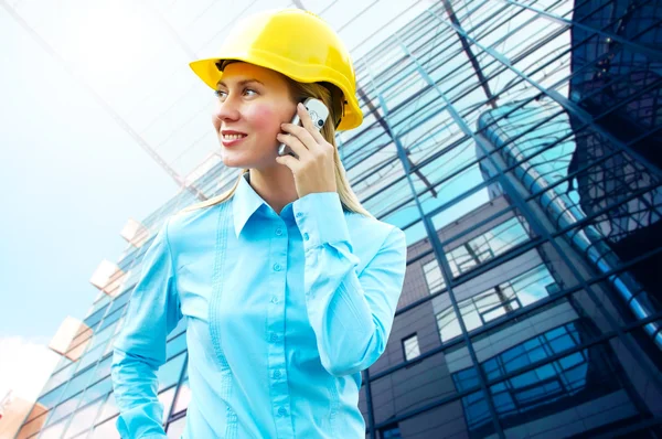 Joven arquitecta-mujer con un casco protector de pie en th —  Fotos de Stock