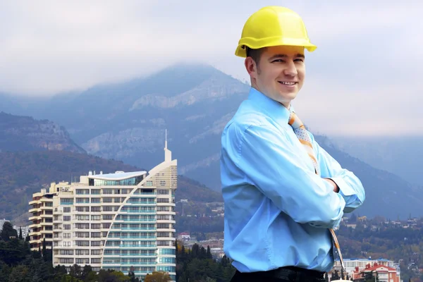 Jonge architect dragen van een beschermende helm staande op de moun — Stockfoto