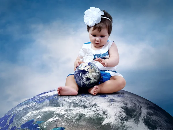 Bambino seduto sul Pianeta Terra con i globi in mano — Foto Stock
