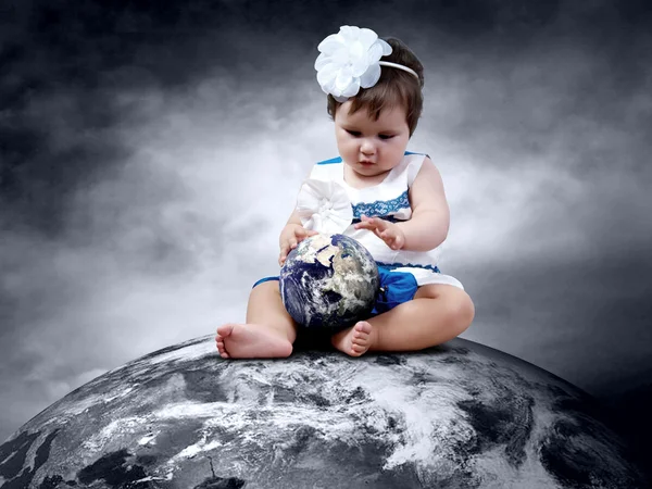 Ребенок, сидящий на планете Земля с глобусами в руках — стоковое фото