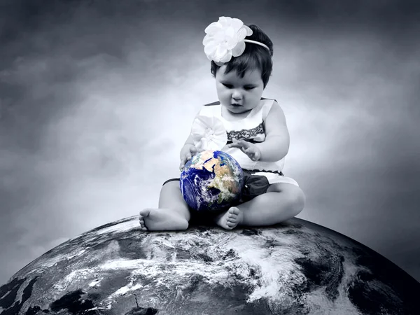 坐在行星地球与地球在手中的儿童 — 图库照片