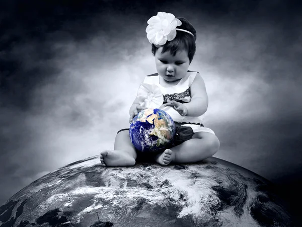 Dziecko siedzi na ziemi z Globus w ręce — Zdjęcie stockowe