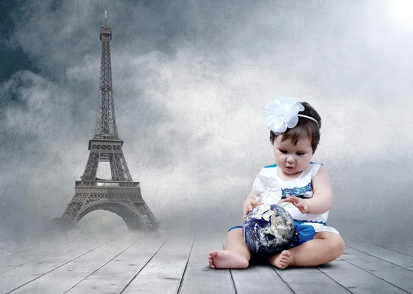 Ребенок сидит с глобусами в руках — стоковое фото