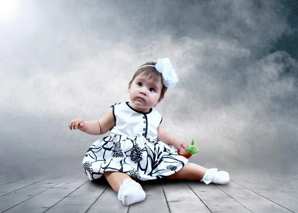 Dítě sedí s koulí v rukou — Stock fotografie