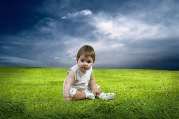 Geluk babymeisje, zittend op het gras in veld — Stockfoto