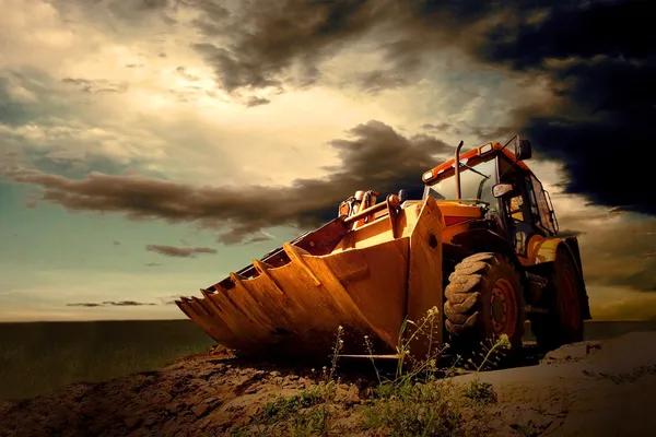 Gul traktor på himmel bakgrund — Stockfoto