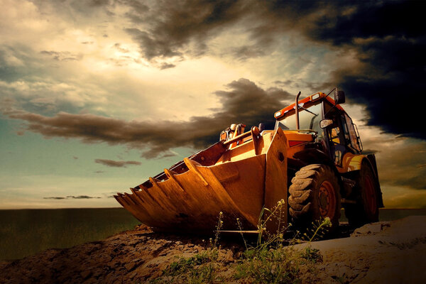 Yellow tractor on sky background