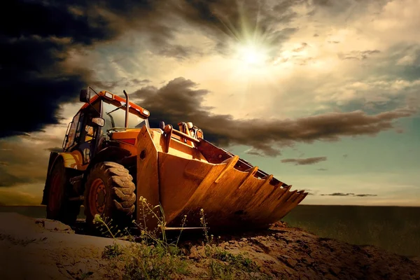 Желтый трактор на фоне неба — стоковое фото