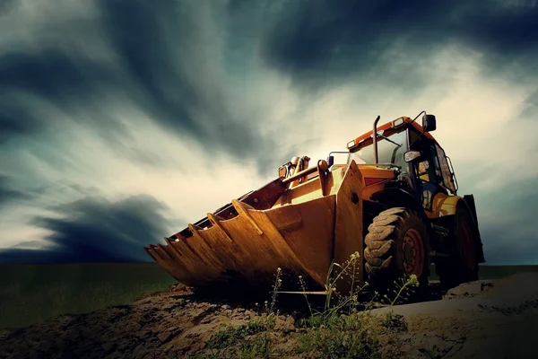 Gelber Traktor auf Himmelshintergrund — Stockfoto