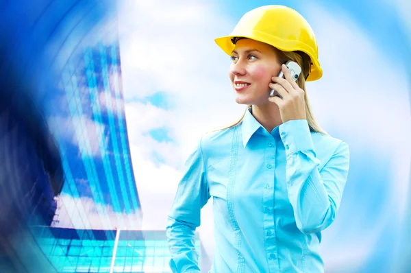 Young architect-woman wearing a protective helmet standing on th Stock Image