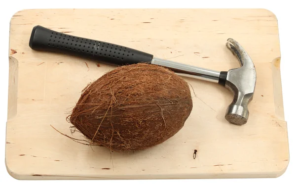 Fruta de coco e um martelo isolado sobre fundo branco — Fotografia de Stock