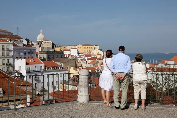 Turistas que apreciam a vista sobre Alfama - a cidade velha de Lisboa, Portugal — Fotografia de Stock