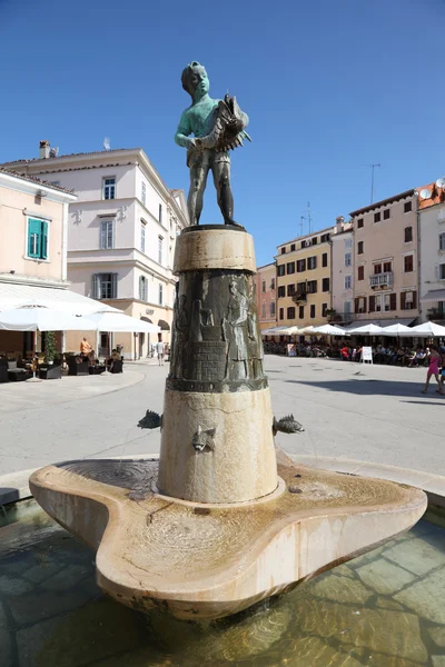 Boy with a fish statue in Rovinj, Croatia — Stock Photo, Image