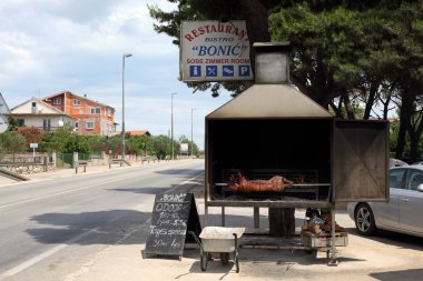 Traditional Croatian Restaurant with a piglet on a spitroast clipart