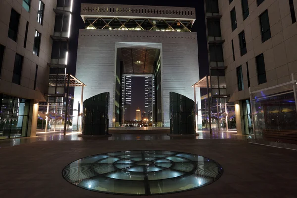 O Centro Financeiro Internacional do Dubai (DIFC) iluminado à noite . — Fotografia de Stock