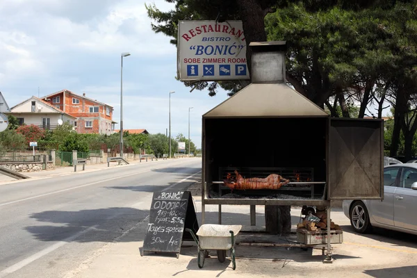 Ristorante tradizionale croato con un maialino su uno spiedino — Foto Stock