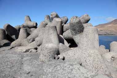 Concrete structures of a breakwater at the beach clipart