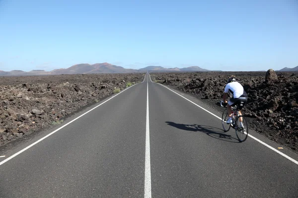 ティマンファヤ国立公園ランサローテ島、スペインでは、道路上のサイクリスト — ストック写真