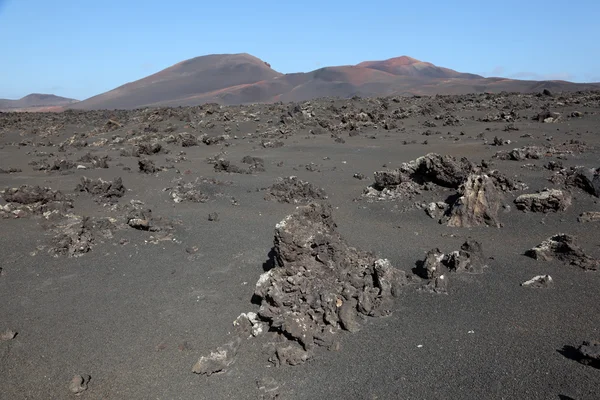Uitzicht over een veld lava naar de montanas del fuego. op de Canarische eiland lan — Stockfoto
