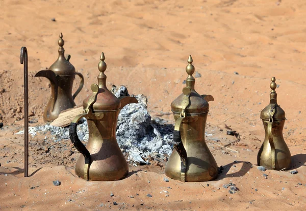 Panelas de café árabes tradicionais na lareira no deserto — Fotografia de Stock