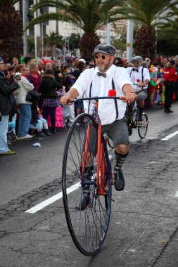 Santa Cruz de Tenerife Carnival 2011: Man riding an antique bike clipart