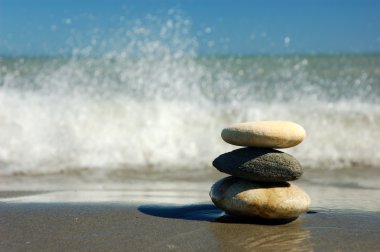 Three balanced stones on the beach clipart