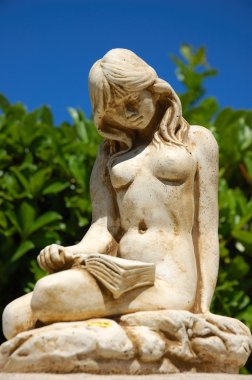 Statue of naked girl reading clipart