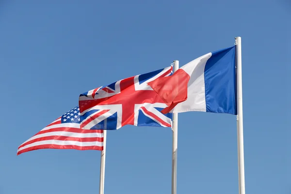 Nationale vlaggen van Groot-Brittannië, VS en Frankrijk tegen blauwe hemel — Stockfoto