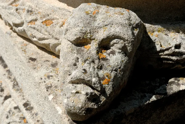 Antigua lápida con un cráneo de piedra —  Fotos de Stock