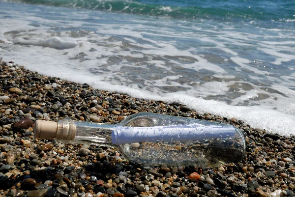 Melding i flasken på stranden – stockfoto