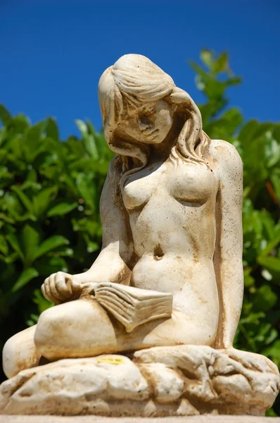 Статуя голой девушки читает — стоковое фото