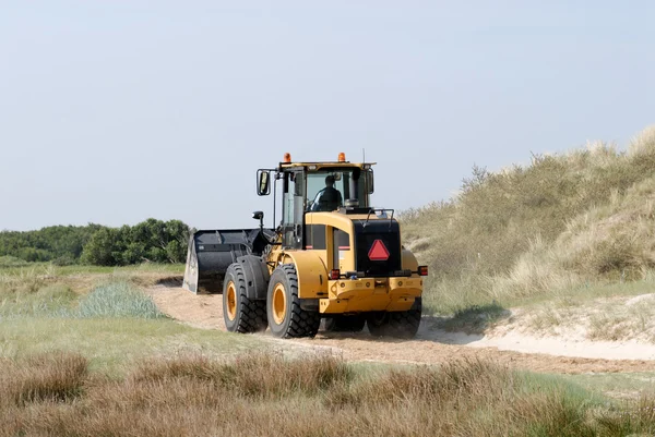 Bulldozer driving fast throw the dunes — Stock Photo, Image