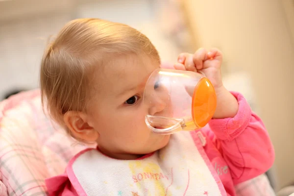 Baby girl drinking out of a cup — Stock Photo, Image
