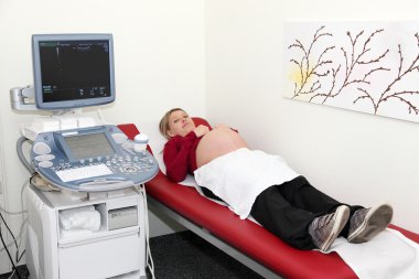 Pregnant woman prepared for ultrasound examination clipart