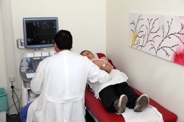 Pregnant woman getting ultrasound examination clipart