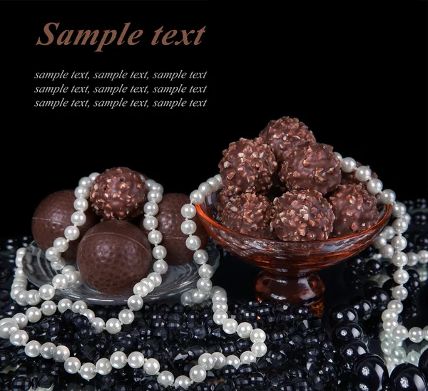 Assortimento di caramelle al cioccolato su piatto, con perle bianche e nere — Foto Stock