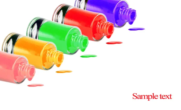 Bottles with spilled nail polish over white background — Stock Photo, Image