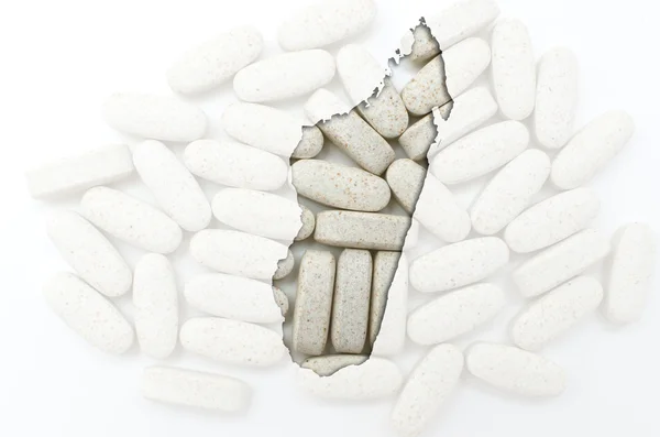Umrisskarte von Madagaskar mit Pillen im Hintergrund zur Heilung — Stockfoto