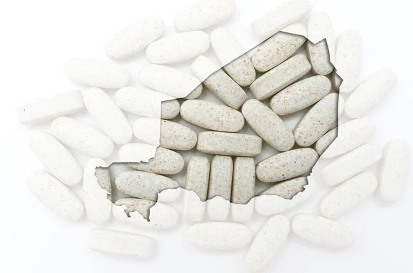 Konturkarta över niger med piller i bakgrunden för hälsa och — Stockfoto