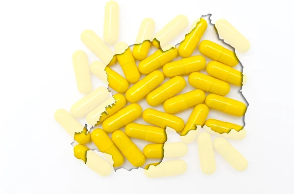 Outline map of rwanda with pills in the background for health an — Stock Photo, Image