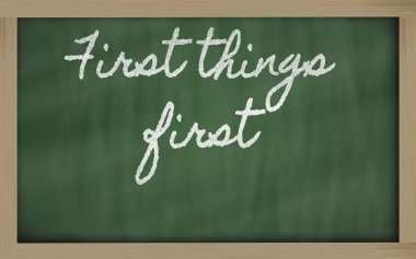 Expression - First things first - written on a school blackboar clipart