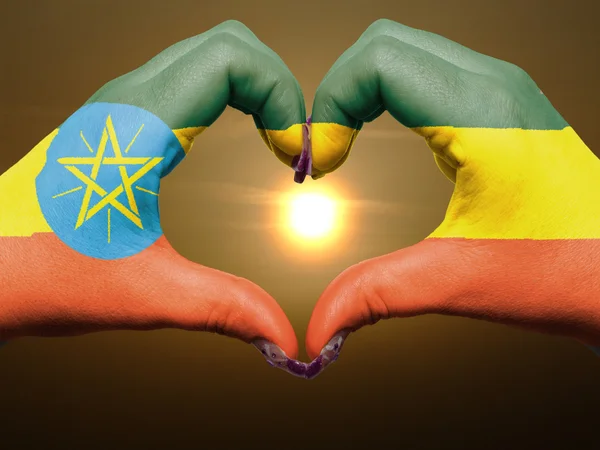Жест любви и сердца руками, раскрашенными в флаг Эфиопии во время — стоковое фото
