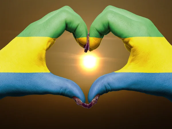 Heart and love gesture by hands colored in gabon flag during bea — Stock Photo, Image